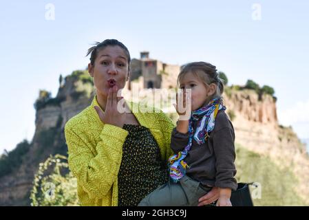 Stilvolle Mutter und Tochter mit Spaß zusammen - Cute Vorschule Mädchen und ihre junge Mutter auf Kamera und weht Ein Kuss - Mutter und Tochter reisen Stockfoto