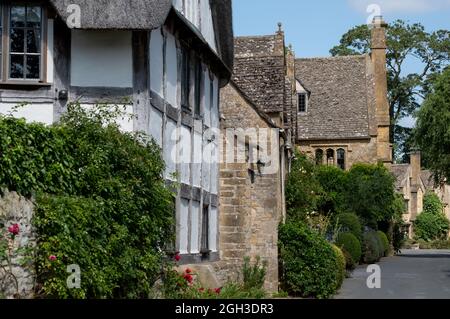 Blick auf die Straße auf hübsche Fachwerk- und Steinhütten im unberührten malerischen Cotswold-Dorf Stanton in Gloucestershire, Großbritannien. Stockfoto