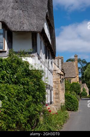 Blick auf die Straße auf hübsche Fachwerk- und Steinhütten im unberührten malerischen Cotswold-Dorf Stanton in Gloucestershire, Großbritannien. Stockfoto