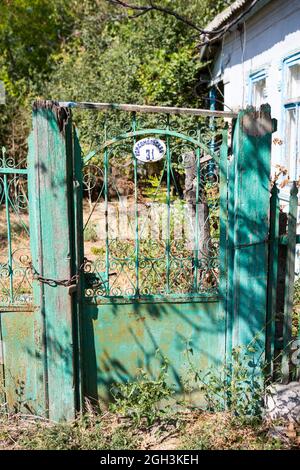 Alte, klapprige Tore. Altes rostiges Tor in einem verlassenen Haus. Kaputtes Tor. Stockfoto