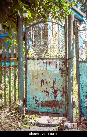 Alte, klapprige Tore. Altes rostiges Tor in einem verlassenen Haus. Kaputtes Tor. Stockfoto