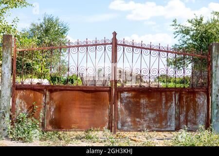 Alte, klapprige Tore. Altes rostiges Tor in einem verlassenen Haus. Kaputtes Tor. Stockfoto