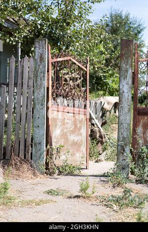 Alte, klapprige Tore. Altes rostiges Tor in einem verlassenen Haus. Kaputtes Tor. Stockfoto