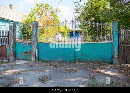 Alte, klapprige Tore. Altes rostiges Tor in einem verlassenen Haus. Kaputtes Tor. Stockfoto