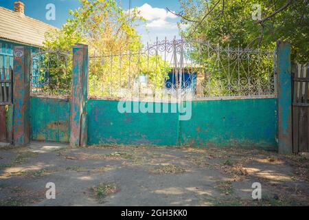Alte, klapprige Tore. Altes rostiges Tor in einem verlassenen Haus. Kaputtes Tor. Stockfoto