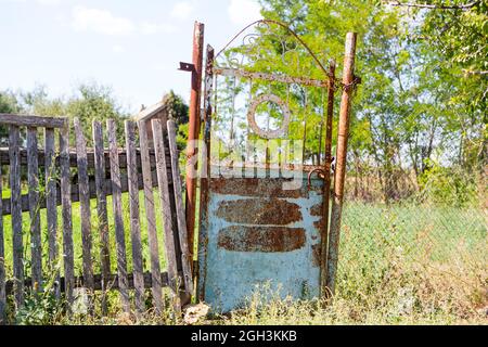 Alte, klapprige Tore. Altes rostiges Tor in einem verlassenen Haus. Kaputtes Tor. Stockfoto