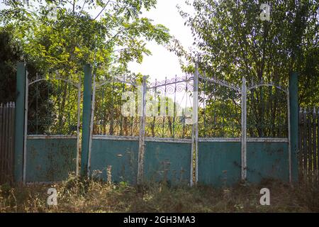 Alte, klapprige Tore. Altes rostiges Tor in einem verlassenen Haus. Kaputtes Tor. Stockfoto