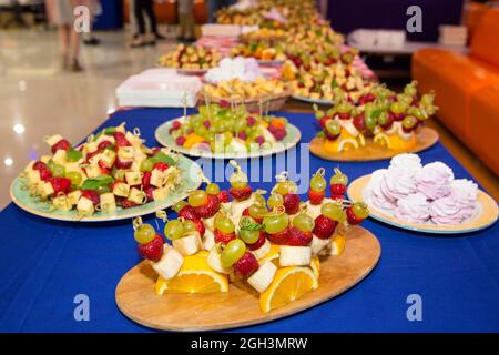 Süßer Buffettisch. Wunderschön dekorierter Catering-Banketttisch mit Burgern, Profiteroles, Salaten und kalten Snacks. Verschiedene leckere Snacks Stockfoto