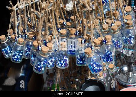 Eine Nahaufnahme von Ampullen mit den blauen türkischen bösen Augenperlen, die auf einem Souvenirshop-Markt verkauft werden Stockfoto