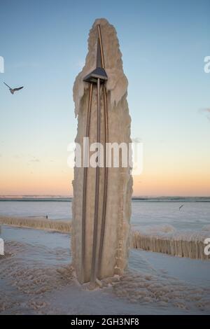 Vereisung. Die Winterkatastrophe, die die Seepromenade nach dem Wintersturm überzieht. Uferung des Ozeans während der Vereisung Stockfoto