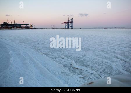 Vereisung. Die Winterkatastrophe, die die Seepromenade nach dem Wintersturm überzieht. Uferung des Ozeans während der Vereisung Stockfoto