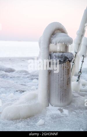 Vereisung. Die Winterkatastrophe, die die Seepromenade nach dem Wintersturm überzieht. Uferung des Ozeans während der Vereisung Stockfoto