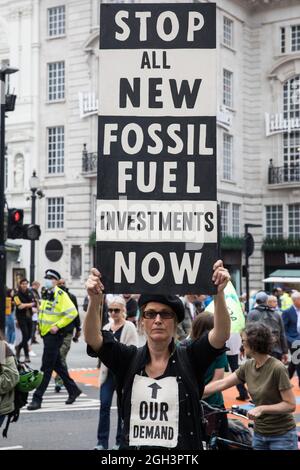 London, Großbritannien. September 2021. Ein Klimaaktivist der Aussterbungsrebellion hält während eines Marsches für die Natur am letzten Tag ihrer zweiwöchigen „Impossible Rebellion“ ein Zeichen für ein Ende der Investitionen in fossile Brennstoffe auf. Die UN-Klimakonferenz 2021 (COP26) soll vom 1. Bis 12. November 2021 unter britischer Präsidentschaft in Glasgow stattfinden. Kredit: Mark Kerrison/Alamy Live Nachrichten Stockfoto