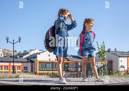 Kleine Mädchen, Grundschüler nach der Schule, auf dem Heimweg. Stockfoto