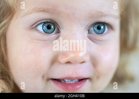 Nahaufnahme Gesicht eines kleinen niedlichen Mädchen mit großen blauen Augen. Stockfoto