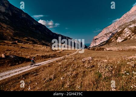 Mans mit Fahrrädern auf Landstraße in den Bergen. Mountainbiken in den Bergen. Stockfoto