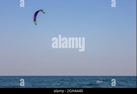 MAMAIA, RUMÄNIEN - 30. Jul 2021: Ein Rüde, der am Schwarzen Meer Kitesurfen macht, im Mamaia Resort, Rumänien Stockfoto