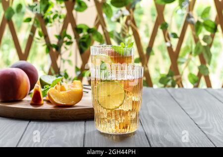 Sommermocktail oder Eistee aus Pfirsich, Limette und Minze Stockfoto