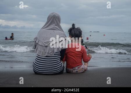 Makassar, Süd-Sulawesi, Indonesien. September 2021. Eine Reihe von Bewohnern genießen das Wochenende, indem sie sich am Strand entspannen. Nach der Entspannung der Aktivitäten der Regierung während der Pandemie von Covid-19 konnten viele Bewohner Erholung und Reisen am Strand Unternehmen. (Bild: © Herwin Bahar/ZUMA Press Wire) Stockfoto