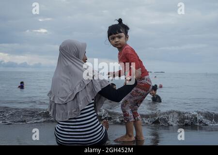 Makassar, Süd-Sulawesi, Indonesien. September 2021. Eine Reihe von Bewohnern genießen das Wochenende, indem sie sich am Strand entspannen. Nach der Entspannung der Aktivitäten der Regierung während der Pandemie von Covid-19 konnten viele Bewohner Erholung und Reisen am Strand Unternehmen. (Bild: © Herwin Bahar/ZUMA Press Wire) Stockfoto