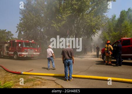 Reno, Usa. September 2021. Bewohner der Nachbarschaft beobachten Feuerwehrleute reagieren auf ein Haus Feuer.Feuerwehrleute gearbeitet, um zu löschen und Dachboden Feuer in einem einzigen Familienhaus. Die Ursache wird noch untersucht. Kredit: SOPA Images Limited/Alamy Live Nachrichten Stockfoto