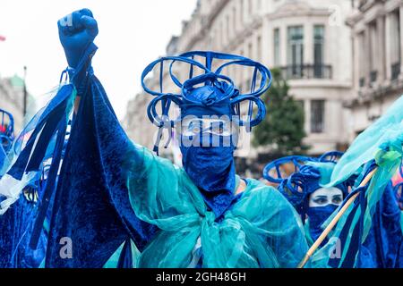 London, Großbritannien. September 2021. Ein Protestler in Blau mit weißem Gesicht hebt seinen Arm mit geballter Faust, während der „Marsch für die Natur“ von Extinction Rebellion am letzten Tag der 14 Tage der Aktion „Unmögliche Rebellion“ über die Krise der Natur, wobei alle 5 Minuten eine Art ausstirbt. Kredit: SOPA Images Limited/Alamy Live Nachrichten Stockfoto