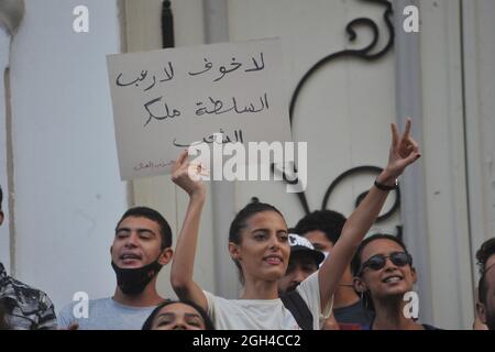 Non Exclusive: TUNISIA CITY, TUNESIEN - 4. SEPTEMBER: Eine Frau hebt ein Plakat, während sie an einer Demonstration gegen den Besuch der Amerikanerin teilnimmt Stockfoto