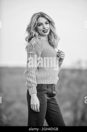 Wunderschöne Dame, die sich im Pullover aus Wolle gemütlich fühlt. Trendige Kleidung. Frau warmer Pullover Natur Hintergrund entschärft. Elegance Konzept. Schickes Mädchen Schminkgesicht Stockfoto