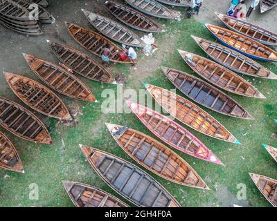 Manikganj, Dhaka, Bangladesch. September 2021. Als der Monsun über dem Distrikt Manikganj, Dhaka, Bangladesch aufragt, waren die Bootshersteller in diesem Distrikt sehr beschäftigt mit dem Bau von Booten, die in dieser Saison in ländlichen Gebieten als Schiffe eingesetzt werden. Die Nachfrage nach Dingi und Khosa Nauka (Kleinboot) ist hier nach regelmäßigen Bewegungen von Menschen in hochwassergefährdeten Gebieten gestiegen. Käufer von außerhalb des Bezirks, darunter Savar und Aminbazar von Dhaka, drängen Ghior Haat, Manikganj, um Boote zu kaufen. Auf diesem traditionellen Markt werden Hunderte von handgefertigten Holzbooten zum Verkauf auf dem Rasen bei A mar angelegt Stockfoto