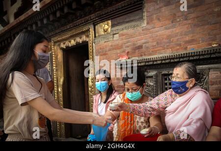 Kathmandu, Bagmati, Nepal. September 2021. Matina Shakya (L), die ehemalige lebende Göttin Kumari, erhält während des Pancha Dan Festivals in Kathmandu, Nepal, am 5. September 2021 Opfergaben von buddhistischen Anhängern. Pancha Dan, das Fest der fünf Sommergeschenke, wird von den Buddhisten beobachtet, indem sie fünf Elemente wie Weizenkörner, Reiskörner, Salz, Geld und Obst verschenken. (Bild: © Sunil Sharma/ZUMA Press Wire) Stockfoto