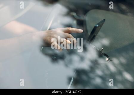 Navigator im Pkw-Transport Pendler. Fahrer Mann zeigt Hand Finger Handy Navigator App während der Fahrt Auto. Stockfoto