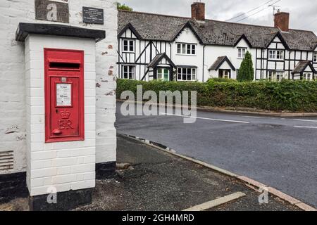 Briefkasten im Dorf Berriew in der Nähe von Montgomery, Powys, Wales. Eine Tafel über der Schachtel erinnert an einen Besuch der Königin im Jahr 1986. Stockfoto