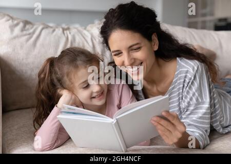 Glückliche Bonding Familie lesen Papierbuch zusammen zu Hause. Stockfoto