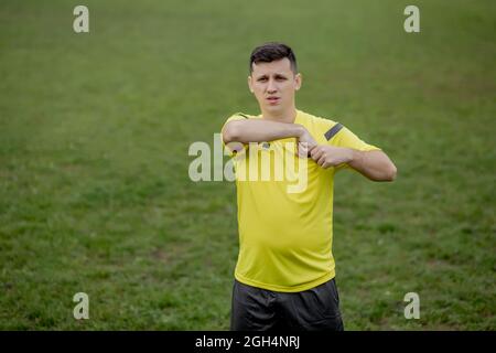 Fußballschiedsrichter, um einen Spieler im Fußballstadion auf eine gelbe Karte hinzuweisen. Stockfoto