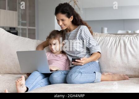 Lächelndes Binden Familie mit verschiedenen Gadgets zu Hause. Stockfoto