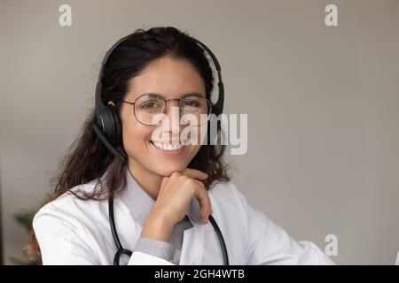 Porträt einer glücklichen jungen Ärztin mit Headset und Brille Stockfoto