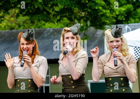 Manhattan Dolls singen in England bei einer militärischen Wiederbelebung Veranstaltung. Sängerinnen aus Amerika besuchen Großbritannien und tragen USAAF-Uniformen Stockfoto