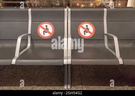 BARCELONA, SPANIEN - 18,2021. AUGUST: Sitzreihe im Flughafen im Abflugterminal von Barcelona ohne Sitz und halten Sie die Distanzschilder Stockfoto