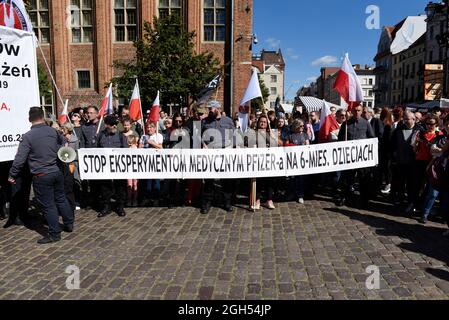 Torun, Polen, Polen. September 2021. Während eines Anti-vax-Protestes am 5. September 2021 in Torun, Polen, halten Menschen ein Transparent mit der Aufschrift „„Stoppt medizinische Experimente von Pfizer an 6 Monate alten Kindern“. Einige hundert Personen nahmen an einer Kundgebung Teil, die von der Partei der rechtsextremen Konföderation (Konfederacja) gegen obligatorische Impfstoffe, die Einführung des grünen COVID-19-Zertifikats, bekannt als Green Pass, und die Beschränkungen, die eingeführt wurden, um die Ausbreitung des SARS-CoV-2 Coronavirus einzudämmen. (Bild: © Aleksander Kalka/ZUMA Press Wire) Stockfoto