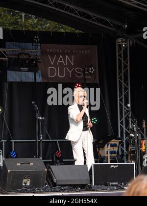 Sint Gillis Waas, Belgien, 04. September 2021, eine Performerin in weißem Anzug singt Lieder auf dem lokalen Straßenfest Stockfoto