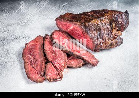 Gebratener Aufhänger oder Onglet-Rindersteak in Scheiben auf einem Tisch. Weißer Hintergrund. Draufsicht Stockfoto