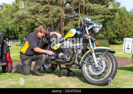 Ayr, Großbritannien. September 2021. Mitglieder des Ayr Vintage Motorcycle Club hielten eine Ausstellung einiger der Motorräder ab, die restauriert wurden und im Besitz von Clubmitgliedern sind. Der Club mit über 80 Mitgliedern besitzt insgesamt mehr als 500 Oldtimer- und Oldtimer-Motorräder. Bild von Ricky Leiper aus Ayr, der sein Motorrad mit 1100 ccm Hubraum von 1995 Moto Guzzi California poliert. Kredit: Findlay/Alamy Live Nachrichten Stockfoto