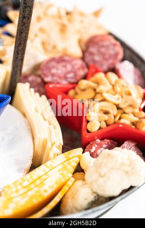 Am 4. Juli gab es ein Charcuterie-Brett auf einem zweistufigen Metallständer, gefüllt mit Käse, Crackern, Salami und frischem Obst Stockfoto