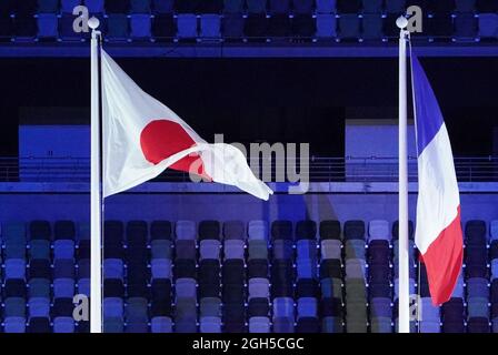 Tokio, Japan. September 2021. Paralympics: Abschlussfeier im Olympiastadion. Bei der Abschlussfeier der Paralympischen Spiele fliegt die französische Flagge (r) im Wind neben der japanischen Flagge. Die nächsten Spiele werden 2024 in Paris stattfinden. Kredit: Marcus Brandt/dpa/Alamy Live Nachrichten Stockfoto