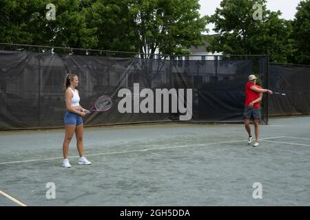 Junge Männer und Frauen spielen Tennis Stockfoto