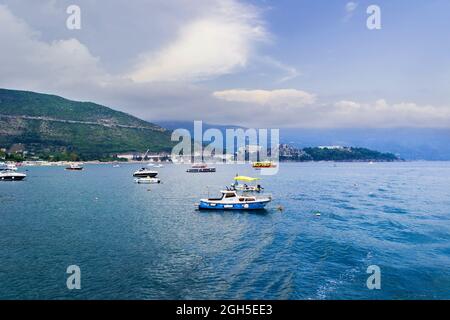 Budva, Montenegro, 16. Juli 2021: Motorboote beim Seefischen. Nahaufnahme der Stadt Budva von einer Yacht, im Hintergrund eine Bergkette mit Stockfoto