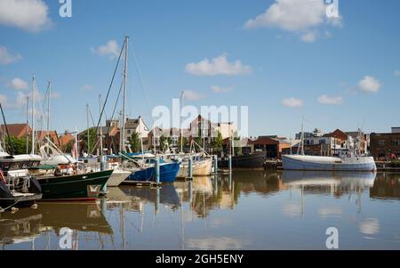 Segelboote und Yachten vor Anker mit Spiegelungen unter bewölkten Himmel am Sommermorgen in der Marina in Hull, Humberside, Großbritannien. Stockfoto