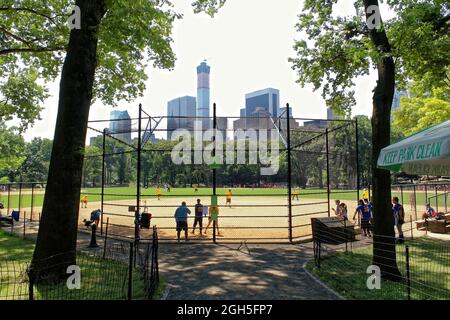 New York, USA - 7. August 2014: New York, NY, USA - 28. JUNI: Baseballspieler im Central Park spielen im Sommer auf einem der 26 Ballfelder Stockfoto