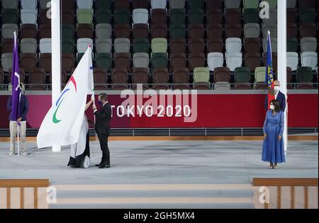 Tokio, Japan. September 2021. Paralympics: Abschlussfeier im Olympiastadion. Andrew Parsons (M), Präsident des Internationalen Paralympischen Komitees, erhält die Paralympische Flagge von Seiko Hashimoto, Präsident des Organisationskomitees der Olympischen und Paralympischen Spiele in Tokio. Auf der rechten Seite ist Anne Hidalgo, Bürgermeisterin von Paris. Die nächsten Sommer-Paralympischen Spiele werden 2024 in Paris stattfinden. Kredit: Marcus Brandt/dpa/Alamy Live Nachrichten Stockfoto