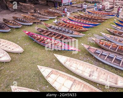 Luftaufnahme von Personen aus Savar und Aminbazar, die am Markt ankommen, um Boote zu kaufen, um sie in ländlichen Gebieten während der Monsunsaison zu benutzen, wenn starker Regen Dörfer und Straßen überflutet, der Preis der Boote ist von BDT 1,500 bis BDT 5,000 (nationale Währung) Je nach Größe und Qualität der verwendeten Materialien. Die Nachfrage nach Dingi und Khosa Nauka (Kleinboot) ist für den Transport von Menschen in hochwassergefährdeten Gebieten gestiegen. Der Markt ist bekannt für den Verkauf von handgefertigten Booten jeden Mittwoch in den letzten 50 Jahren von Juni bis Oktober. Am 5. September 2021 in Manikganj, Bangladesch. (P Stockfoto